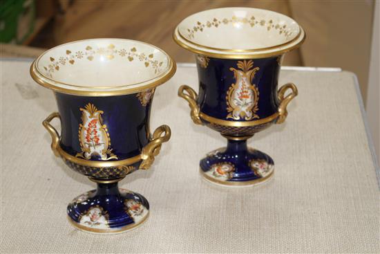 A pair of Victorian Derby style campana vases, painted with panels of flowers within gilt cobalt blue borders, unmarked, height 20cm